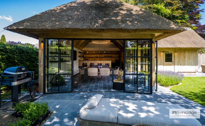 Pool house rustique avec toit de chaume et fenêtres en acier noir Pool house rustique avec toit de chaume et fenêtres en acier noir