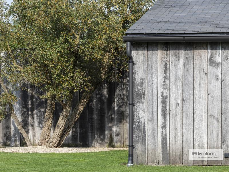 Une continuité harmonieuse entre le bardage en bois de grange et la clôture assortie Une continuité harmonieuse entre le bardage en bois de grange et la clôture assortie