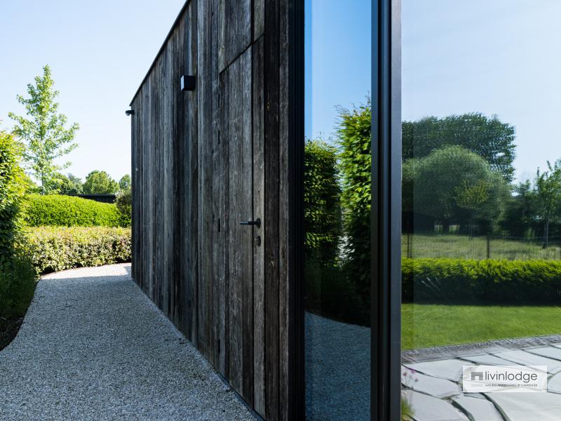 Porte en bois de grange magnifiquement intégrée à la façade de la dépendance en bois